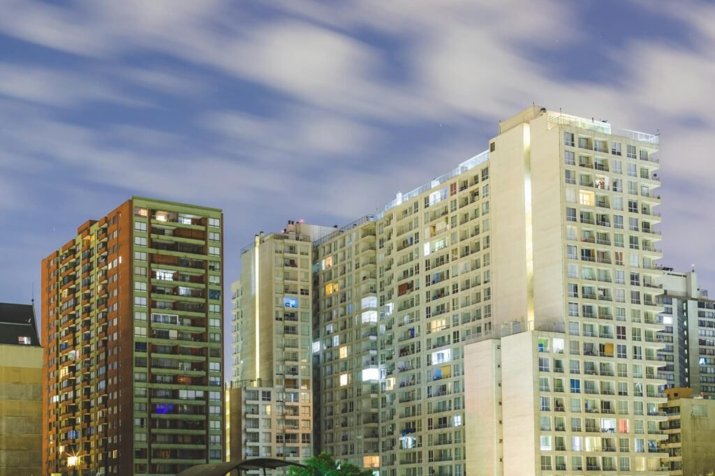 Night view of illuminated modern apartment buildings, showcasing urban architecture in Chile.